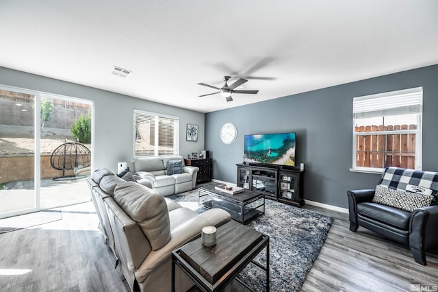 living room with light hardwood / wood-style flooring, ceiling fan, and plenty of natural light