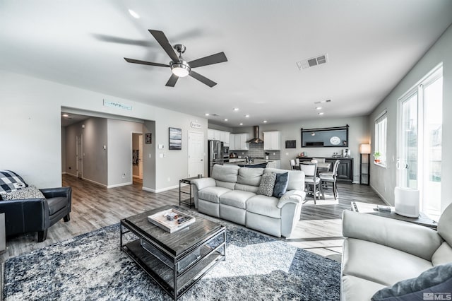 living room with light hardwood / wood-style floors and ceiling fan