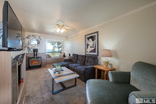 living room featuring a wood stove, ceiling fan, and crown molding