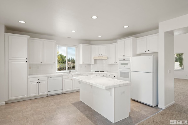 kitchen featuring decorative backsplash, white appliances, white cabinetry, and tile countertops