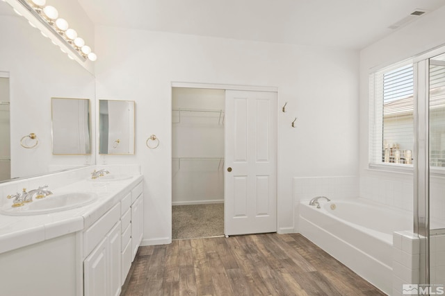 bathroom with vanity, hardwood / wood-style floors, and a tub