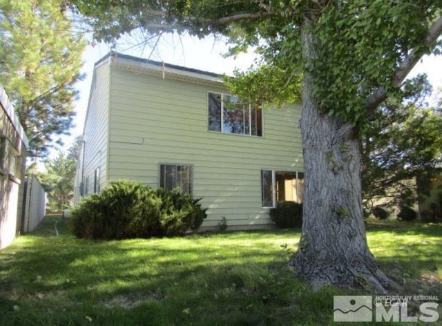 back of house featuring a lawn