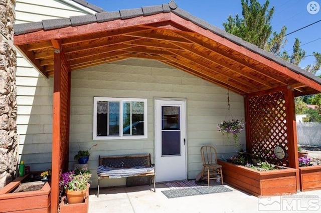 view of exterior entry with a patio