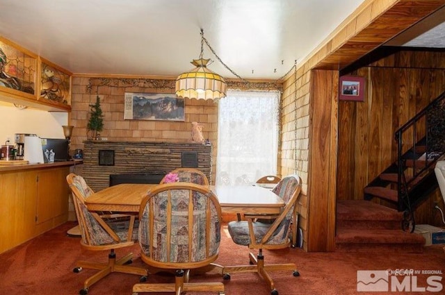 dining area featuring wooden walls and carpet flooring