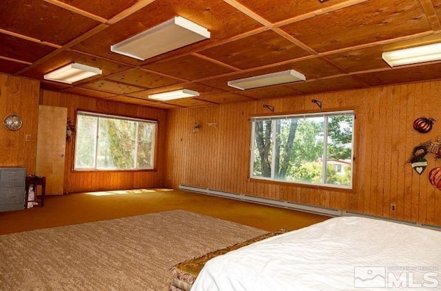 carpeted bedroom featuring a baseboard radiator and wood walls