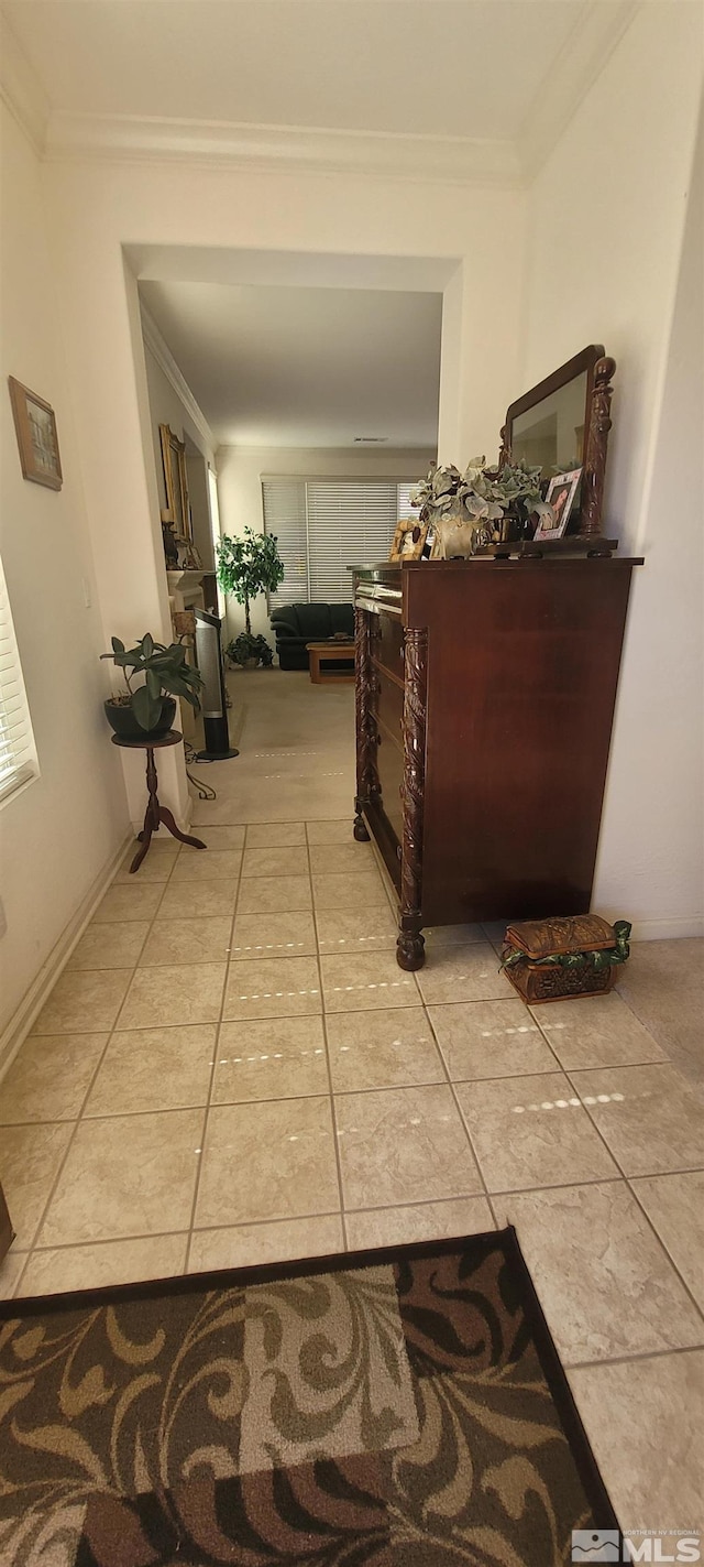 hall featuring light tile patterned floors and ornamental molding