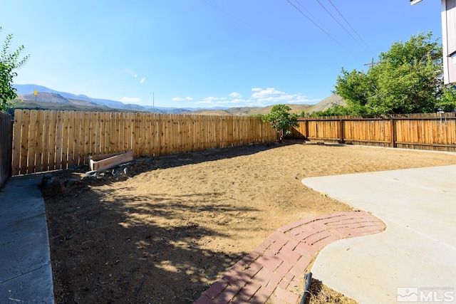 view of yard featuring a patio and a mountain view