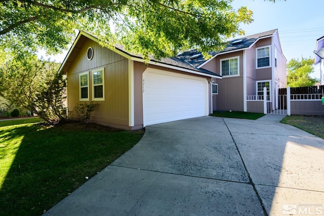 view of front of home with a front yard and a garage