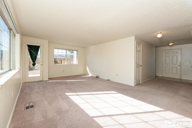 carpeted spare room featuring a textured ceiling