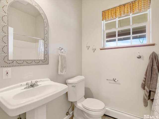 bathroom with a shower with shower curtain, toilet, a baseboard heating unit, and sink