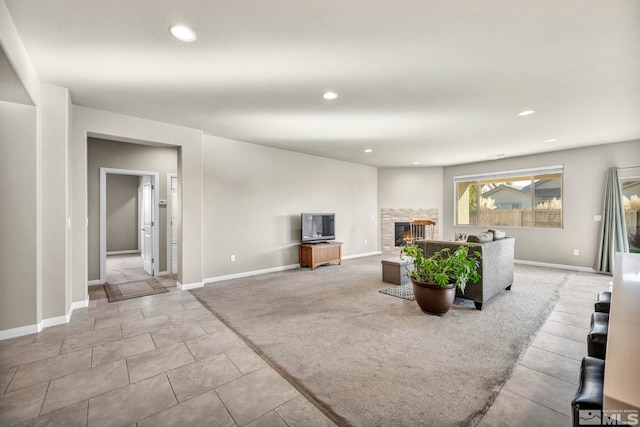 living room featuring light tile patterned floors and a stone fireplace