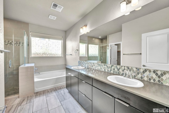 bathroom with vanity, separate shower and tub, and tasteful backsplash