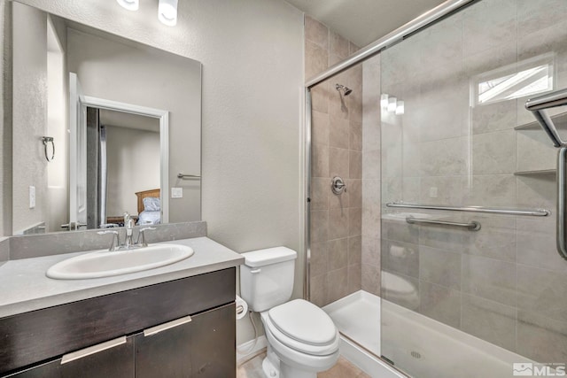 bathroom with vanity, toilet, and a shower with door