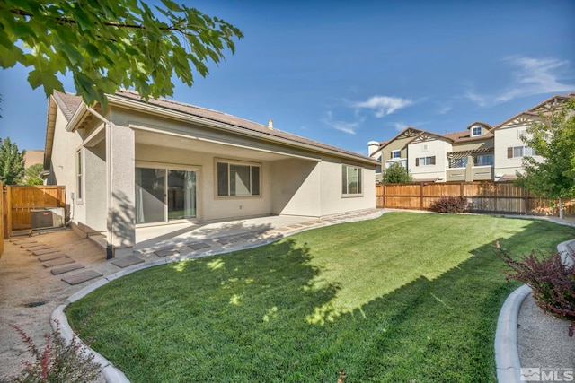 rear view of property featuring a yard, a patio, and central air condition unit