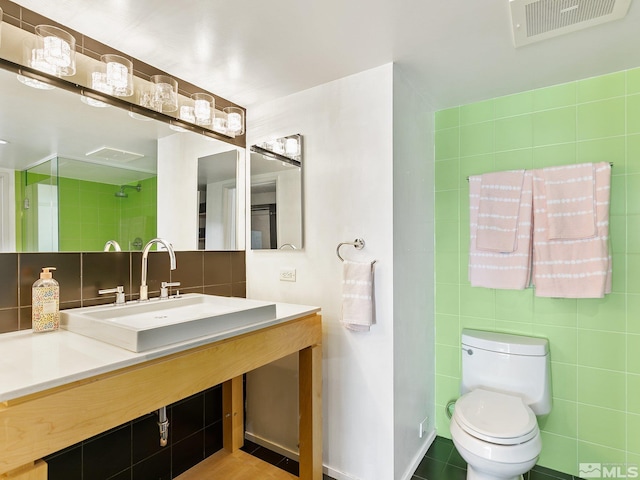 bathroom featuring vanity, tile walls, toilet, and tasteful backsplash