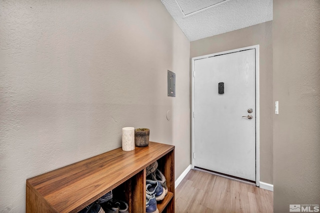 entryway featuring light wood-type flooring and a textured ceiling