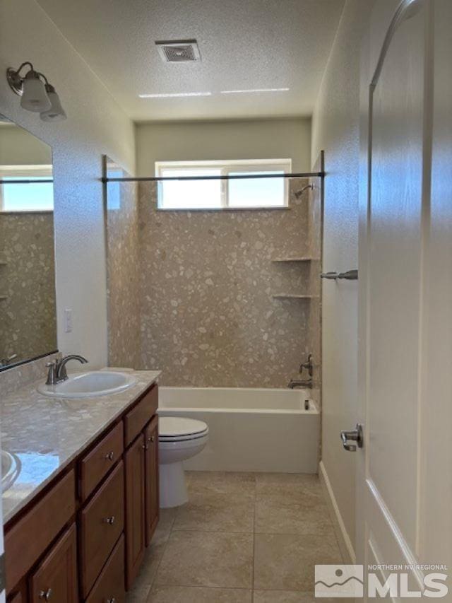 full bathroom featuring a textured ceiling, tiled shower / bath combo, vanity, and toilet