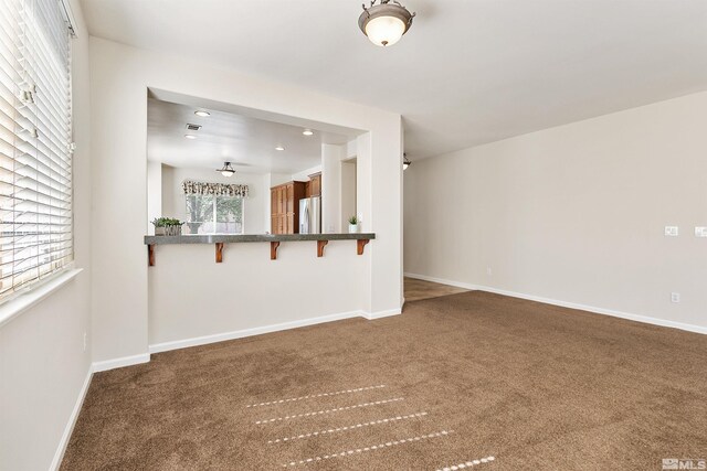 unfurnished living room featuring dark colored carpet