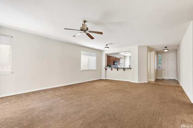 unfurnished living room featuring ceiling fan and carpet floors