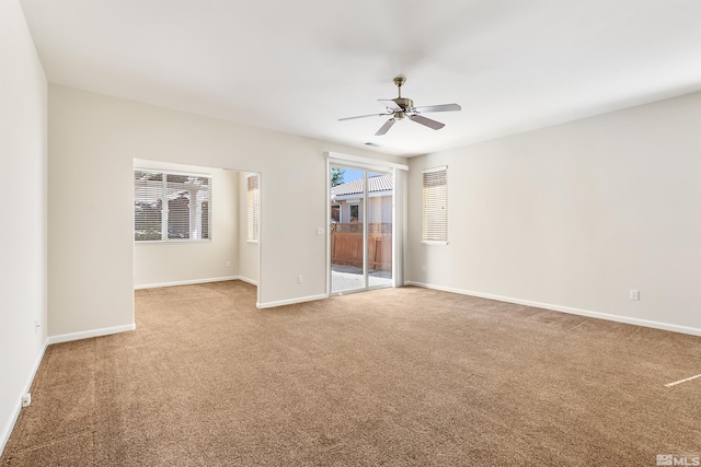 carpeted spare room with ceiling fan