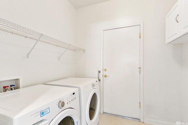 clothes washing area with washing machine and clothes dryer and cabinets