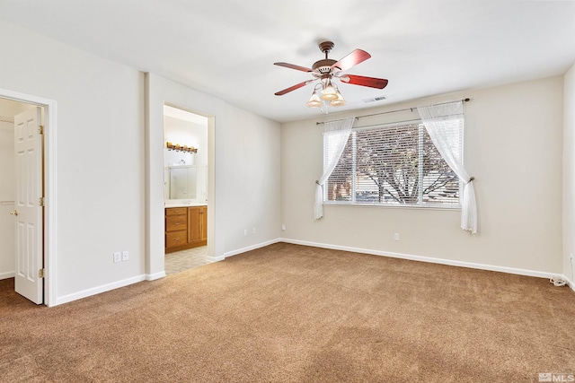 unfurnished bedroom featuring connected bathroom, carpet floors, and ceiling fan