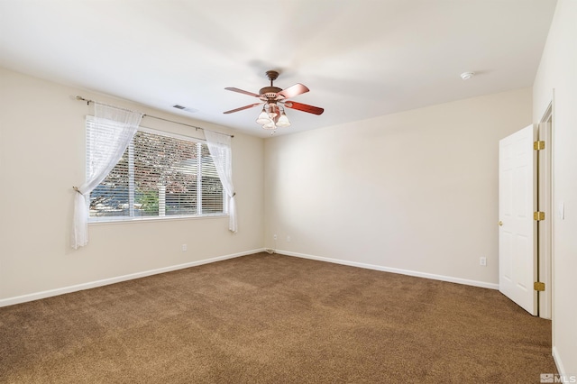 empty room featuring ceiling fan and dark carpet