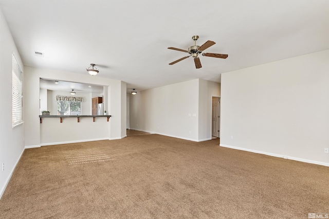 unfurnished living room featuring carpet floors and ceiling fan