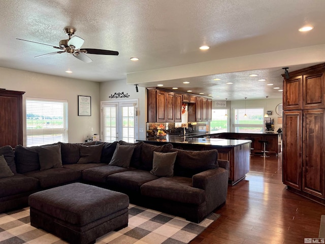 living area featuring dark wood-style floors, french doors, recessed lighting, ceiling fan, and a textured ceiling