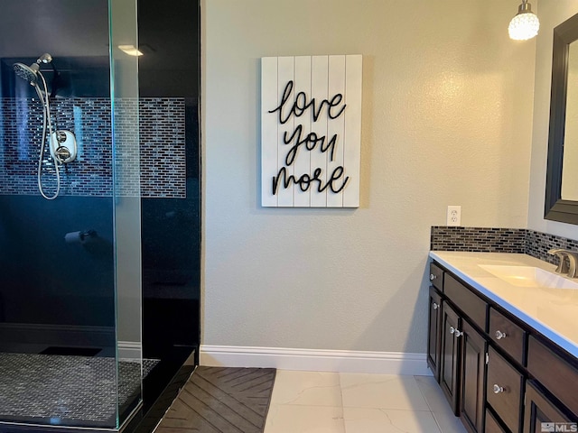 bathroom with baseboards, marble finish floor, a tile shower, vanity, and backsplash