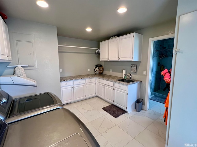 kitchen featuring marble finish floor, washing machine and dryer, a sink, and recessed lighting