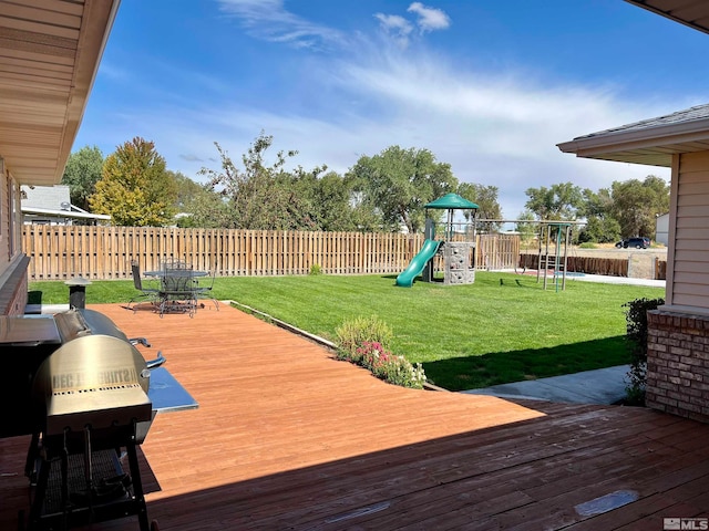 wooden deck featuring a playground, a lawn, and area for grilling