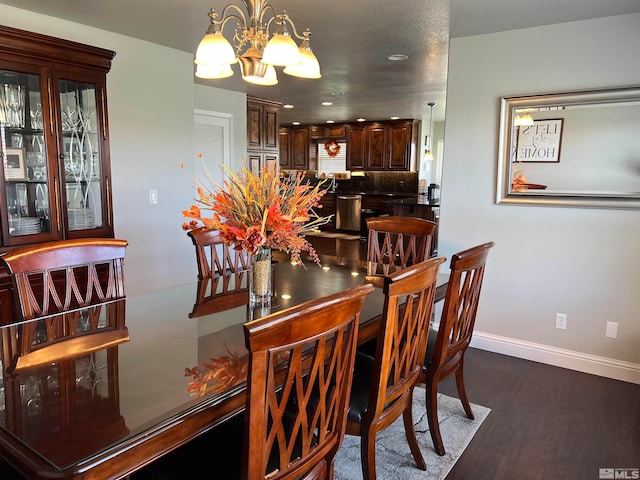 dining room with dark wood-style floors, baseboards, and a notable chandelier