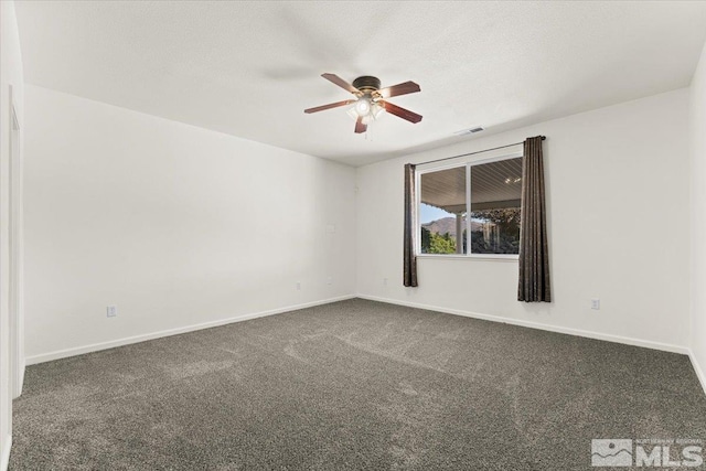 unfurnished room with dark colored carpet, ceiling fan, and a textured ceiling