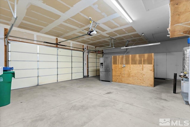 garage featuring a garage door opener and stainless steel fridge with ice dispenser