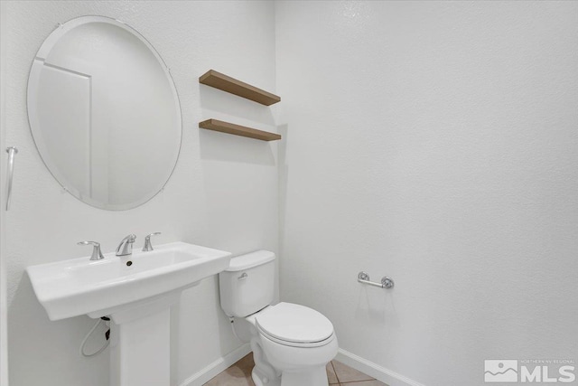 bathroom with toilet and tile patterned floors