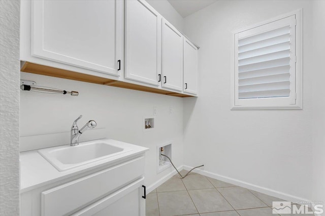 clothes washing area featuring washer hookup, cabinets, sink, and light tile patterned flooring