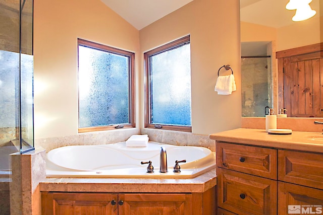 bathroom featuring vanity, plus walk in shower, and vaulted ceiling