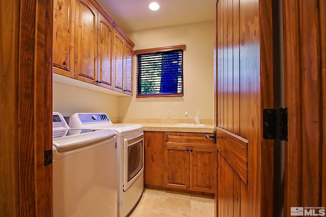 washroom featuring sink, washer and dryer, and cabinets