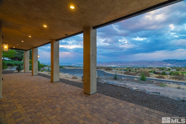 view of patio / terrace with a water and mountain view