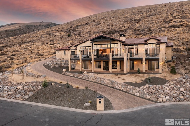 view of front facade featuring a mountain view and a balcony