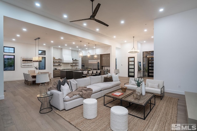 living room with light hardwood / wood-style floors and ceiling fan