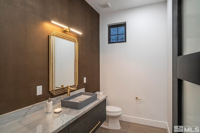 bathroom featuring vanity, toilet, and hardwood / wood-style flooring