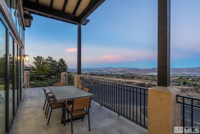 patio terrace at dusk featuring a mountain view