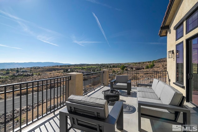 exterior space with a balcony, a mountain view, and outdoor lounge area