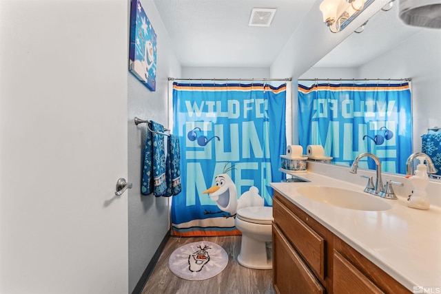 bathroom with curtained shower, hardwood / wood-style floors, vanity, and toilet