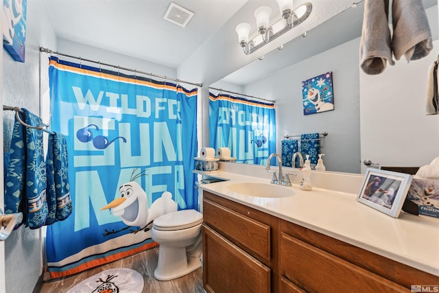 bathroom with wood-type flooring, curtained shower, vanity, and toilet