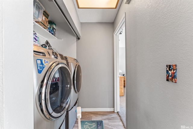 laundry room with a textured ceiling, light hardwood / wood-style floors, and independent washer and dryer