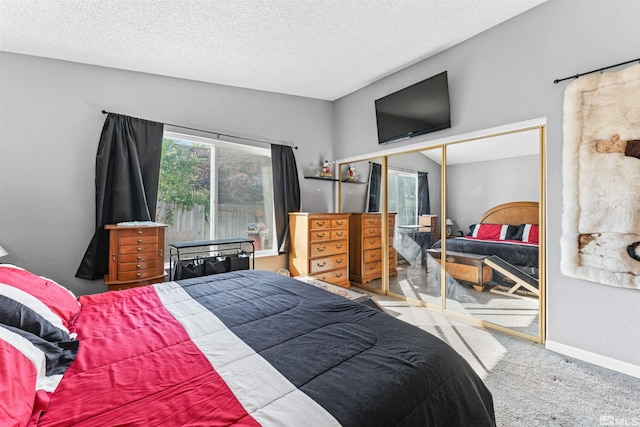 bedroom with a textured ceiling, carpet flooring, and a closet