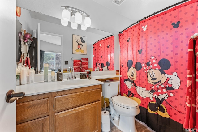 bathroom with wood-type flooring, vanity, lofted ceiling, and toilet